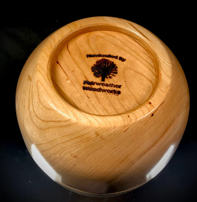 Wooden bowl with 'Fairweather Woodworks' logo on a black background