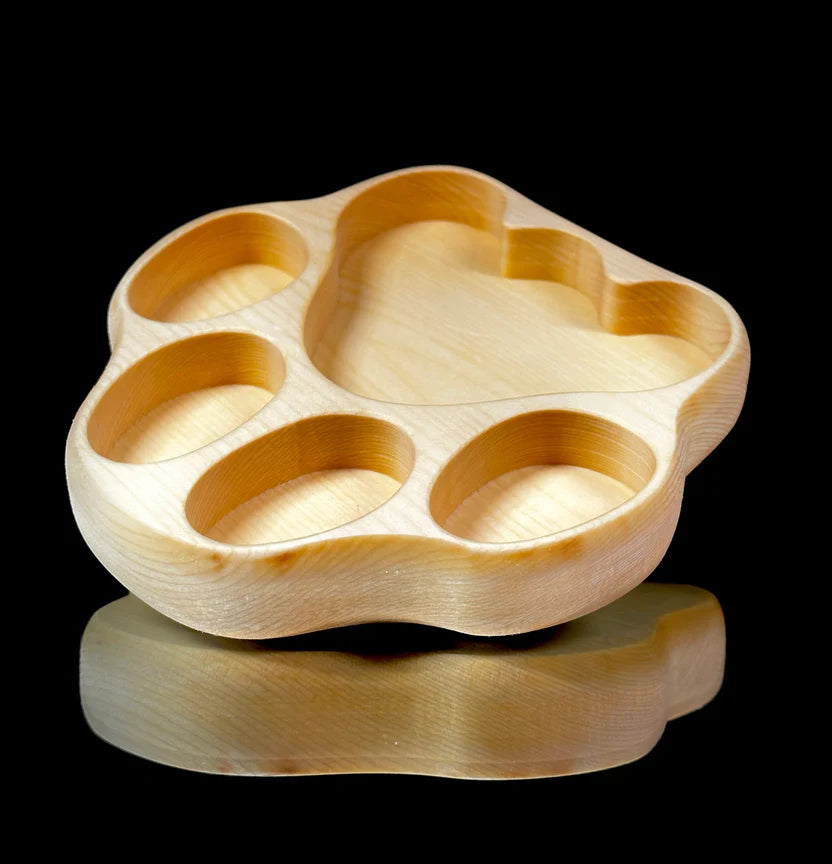 Wooden paw-shaped tray on a black background