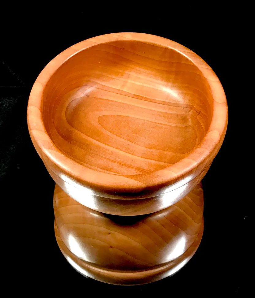 Wooden bowl with a cylindrical base on a black background