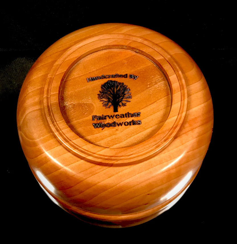 Wooden disc with 'Fairweather Woodworks' branding on a black background