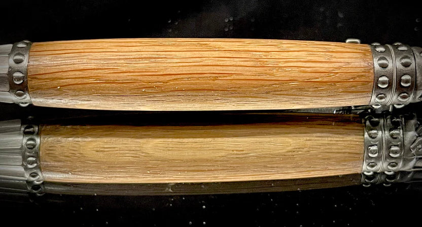 Wooden pen with metal accents on a textured surface